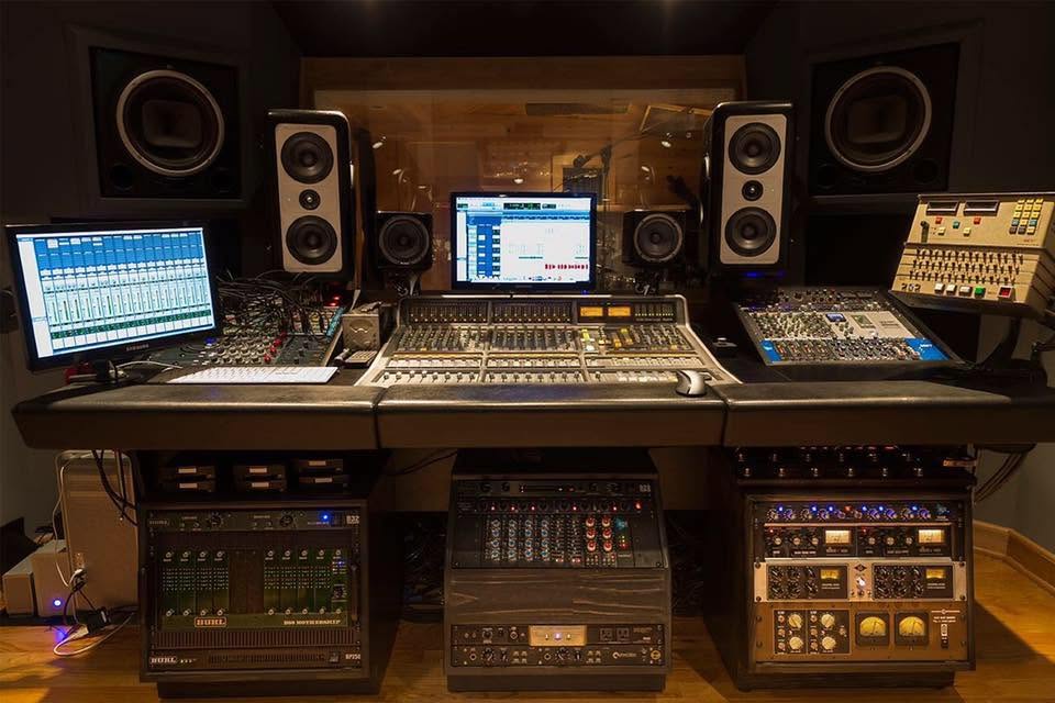 Recording studio workspace with mixing console and outboard equipment