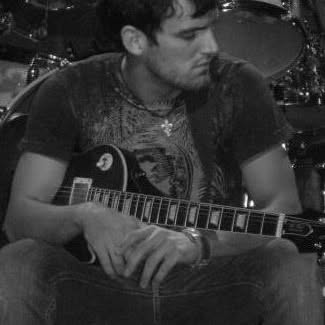 Black-and-white archival photo of Topher with his guitar